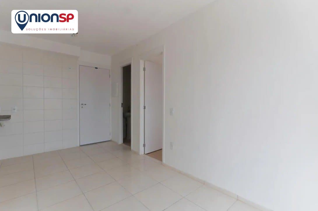 Vista interna da sala mostrando o corredor de acesso aos quartos e porta de entrada.